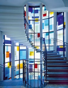 Treppenhaus im Verwaltungsgebäude des Herstellers: Fassade mit farbigen Solarmodulen