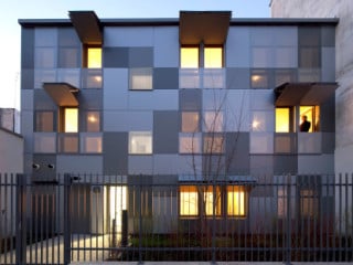 Die Fassade des Wohngebäudes ist mit Aluminiumplatten in verschiedenen Grautönen verkleidet