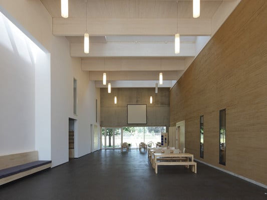 Foyer mit sichtbarer Stampflehmwand des Gottesdienstraums