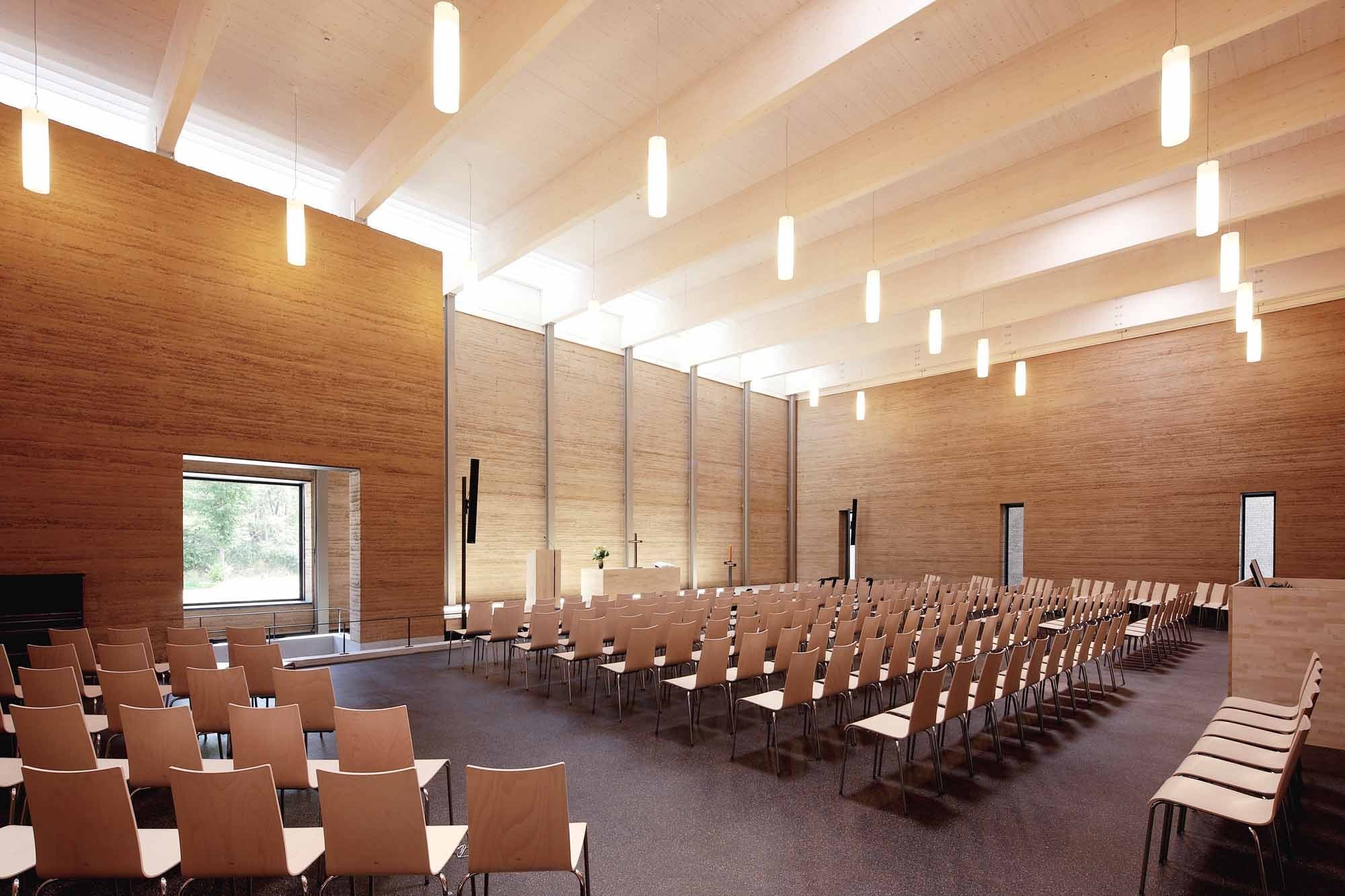 Der von oben belichtete Gottesdienstraum ist von Stampflehmwänden umhüllt