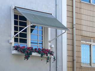 Bei Fallarmmarkisen wird der Behang durch seitliche, um einen Drehpunkt bewegliche Arme geführt.