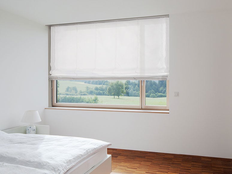 Hier dient ein weißes Raffrollo dem Sichtschutz