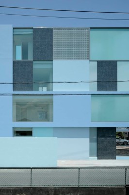 An der Fassade wechseln sich Felder aus Glas, Glasbausteinen, Beton und dunklem Granit ab