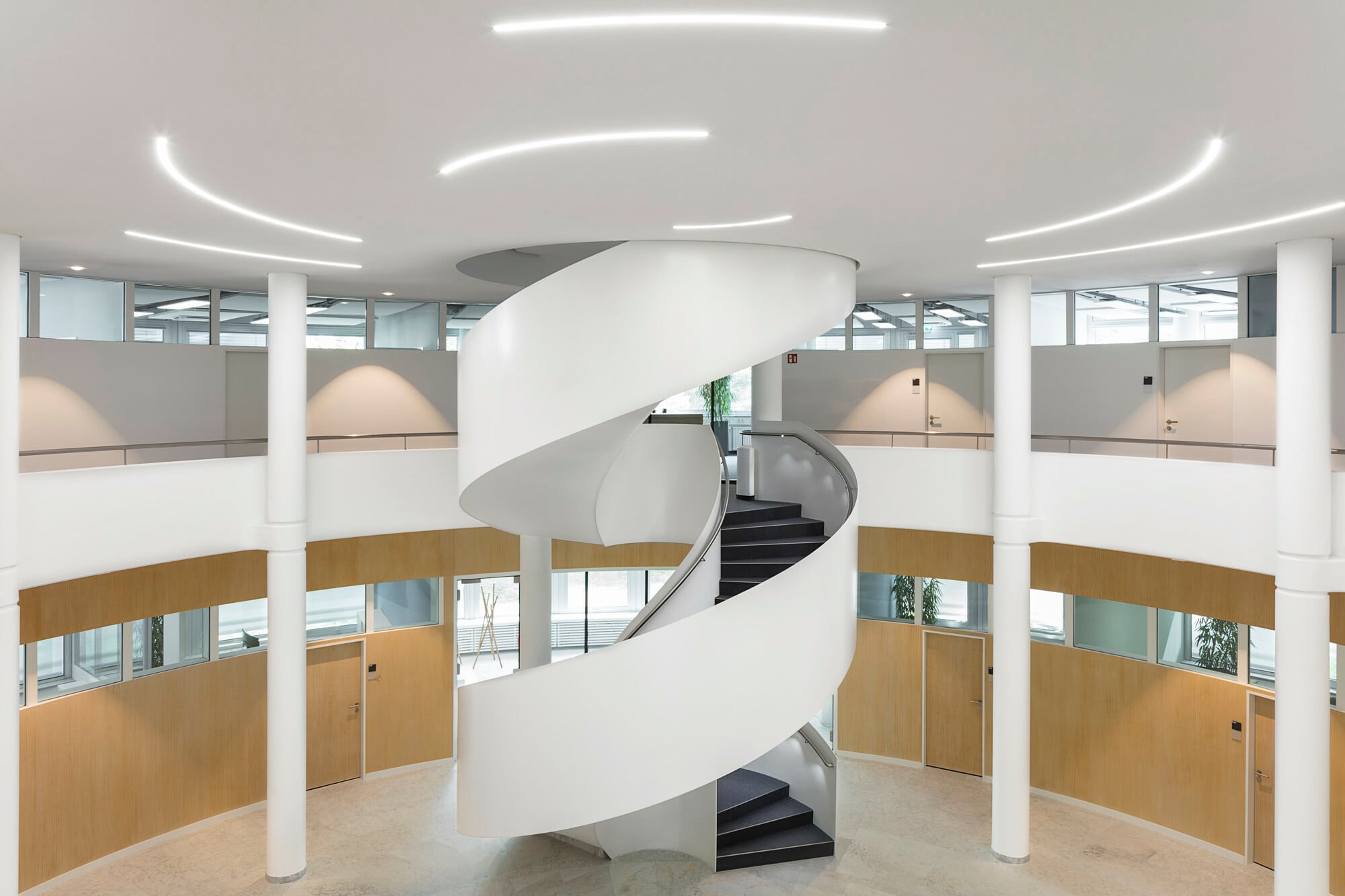 Da Innentreppen nicht der Witterung ausgesetzt sind, müssen ihre Bestandteile weder frost- noch regensicher sein, hier eine gewendelte Betontreppe im Foyer der Firma Truma Gerätetechnik in Putzbrunn.