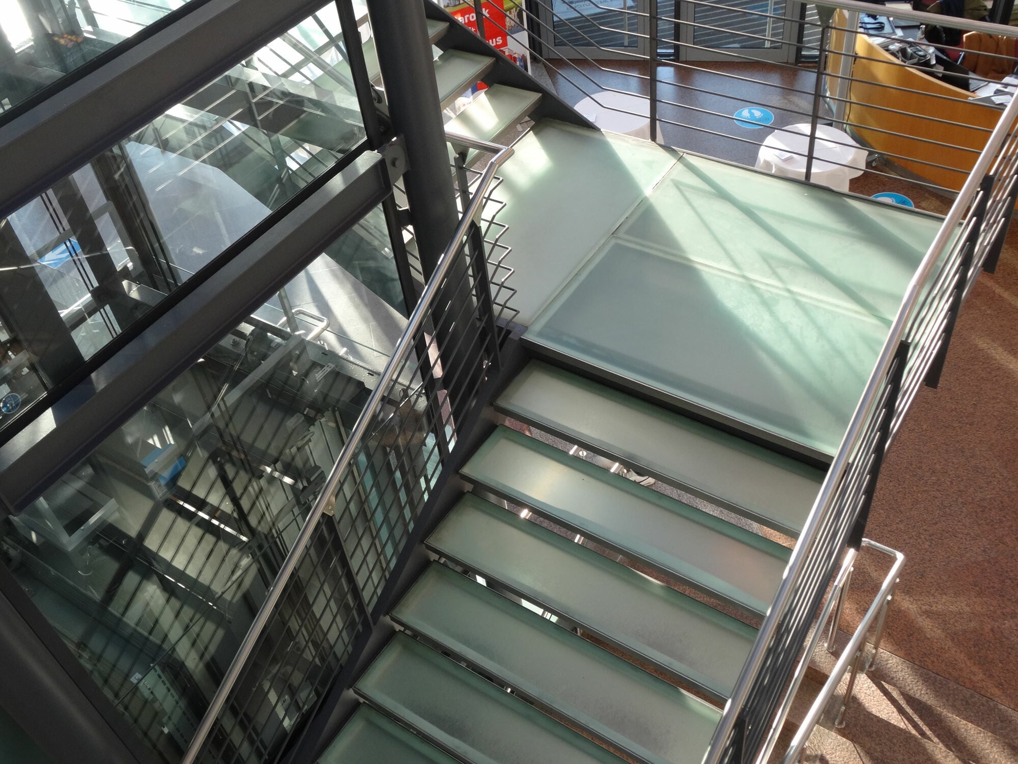 Treppenanlage aus Stahl mit satinierten Glasstufen im Foyer der Congress Union in Celle.