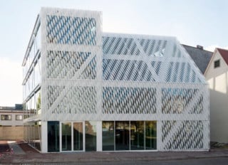 Das vorgelagerte Geflecht aus weißen Edelstahlprofilen bedeckt Fassade und Dach gleichermaßen
