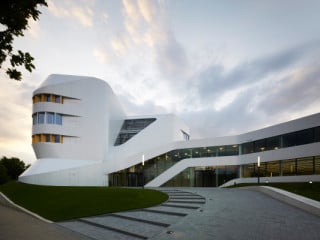 Von der Nobelstraße führt eine außen liegende Rampe zum erhöhten Eingang und Foyer