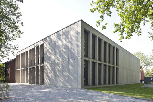 Für die Fassade wählten die Architekten Sichtbetonfertigteile mit mittelgrauer Spliteinstreuung