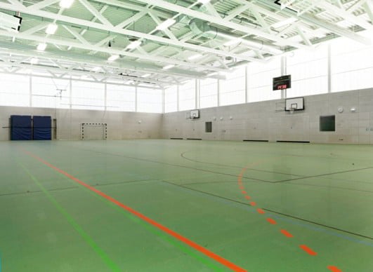 Die transluzenten Polycarbonatplatten oberhalb des Betonsockels sorgen für viel Licht in der Halle