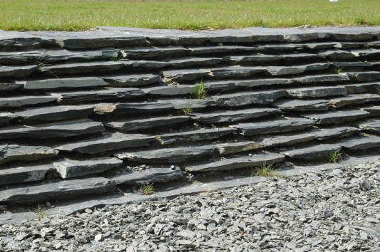 Einfassung der grasbewachsenen, inselähnlichen Flächen durch abgetreppte Schieferplatten