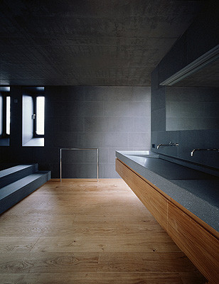 Klare Oberflächen im Badezimmer: Eichenholz, Naturstein und Sichtbeton