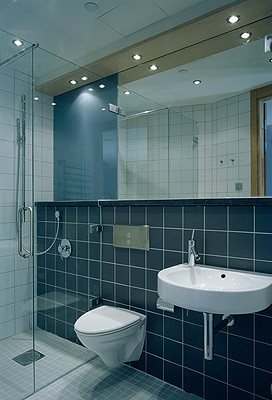 Mit Glastür abgetrennte Dusche und Einhebelmischbatterien am Waschtisch