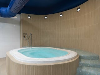 Festinstalliert: Whirlpool in einem gefliesten Podest mit integrierten Treppen