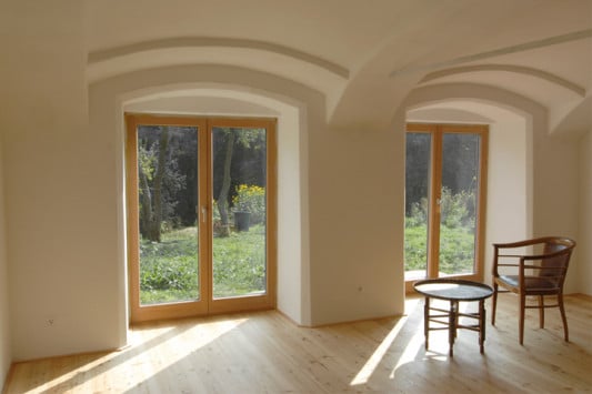 Der von einem Ziegelgewölbe überdeckte Wohnraum öffnet sich mit zweiflügeligen Fenstertüren zur Terrasse im Südgarten