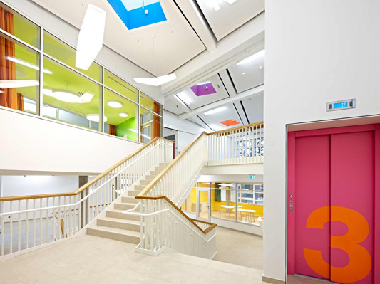 Foyer mit offener Treppe und Sitzstufen als kommunikativer Mittelpunkt der Schule