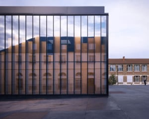 Hinter dem Glas zeigen sich die Kupfertafeln als edle zweite Haut, auf der Fassade spiegelt sich gleichzeitig die Umgebung