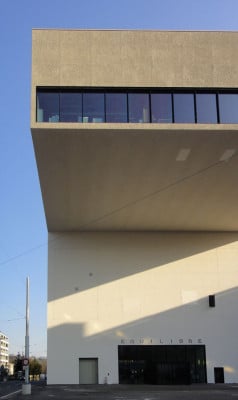 In der schlichten Putzfassade fallen kaschierte Öffnungen und das Tor zum Lastenaufzug ins Auge