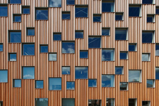Zwei unterschiedlich große quadratische Fensterformate perforieren die Außenhaut der Architekturfakultät