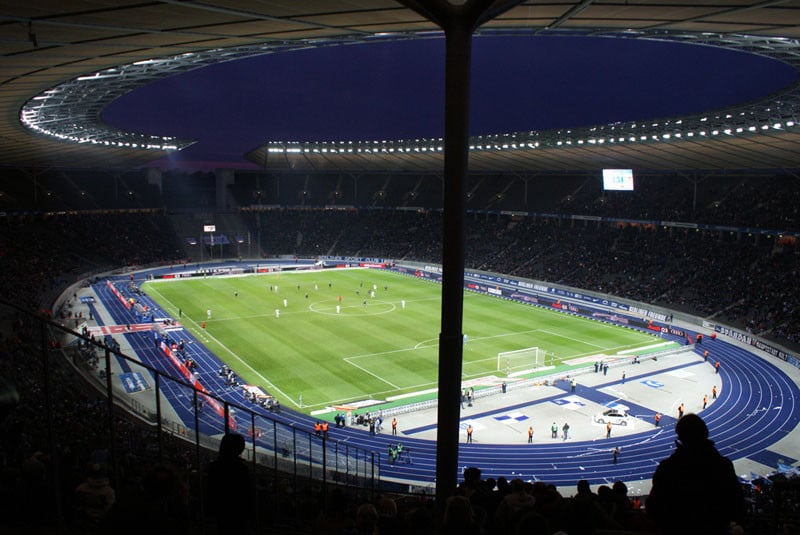 Sie betrifft auch Sportstadien und Freisportanlagen mit Tribünen, die keine fliegenden Bauten sind, die mehr als 5.000 Besucher fassen (Abb.: Olympiastadion Berlin).