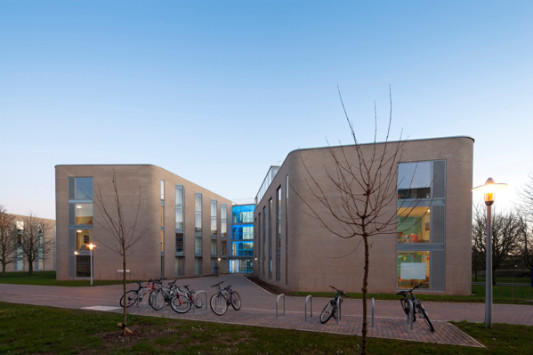 Die Gebäudeflügel eines jeden Blocks leiten die Studierenden mit einladender Geste zum verglasten Eingang