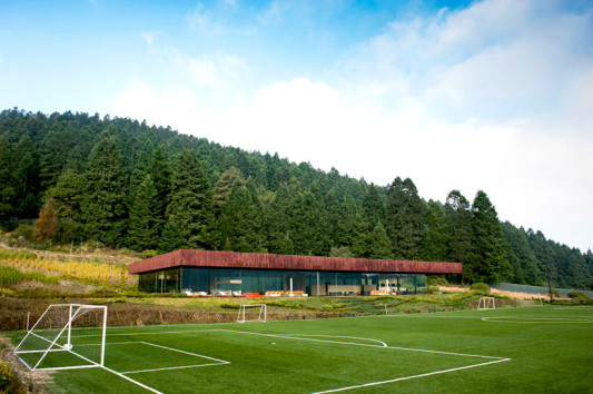 Zum Spielfeld ist das Gebäude größtenteils verglast. Von der erhöhten Terrasse können die Zuschauer das Fußballspiel verfolgen