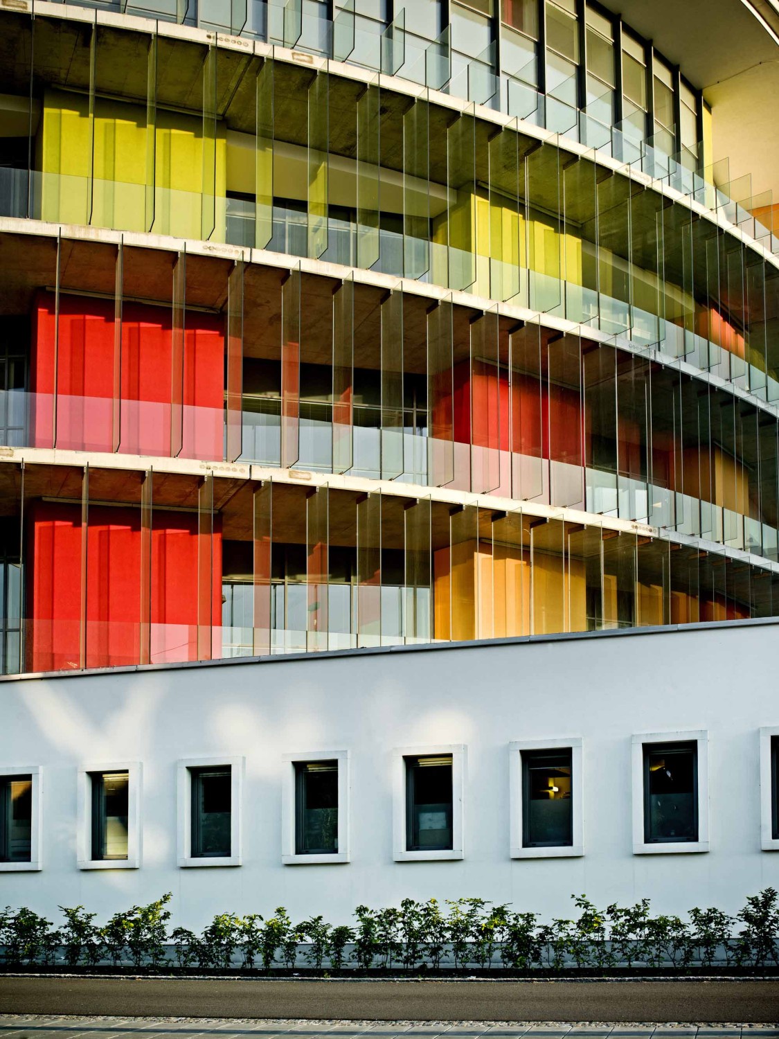 Kräftige Rot- Grün- und Gelbtöne entlang der Fassade 