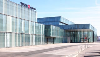 Zur Stadt und zum gegenüberliegenden Bahnhof hin ist der Neubau in niedrige Bauvolumen gegliedert 