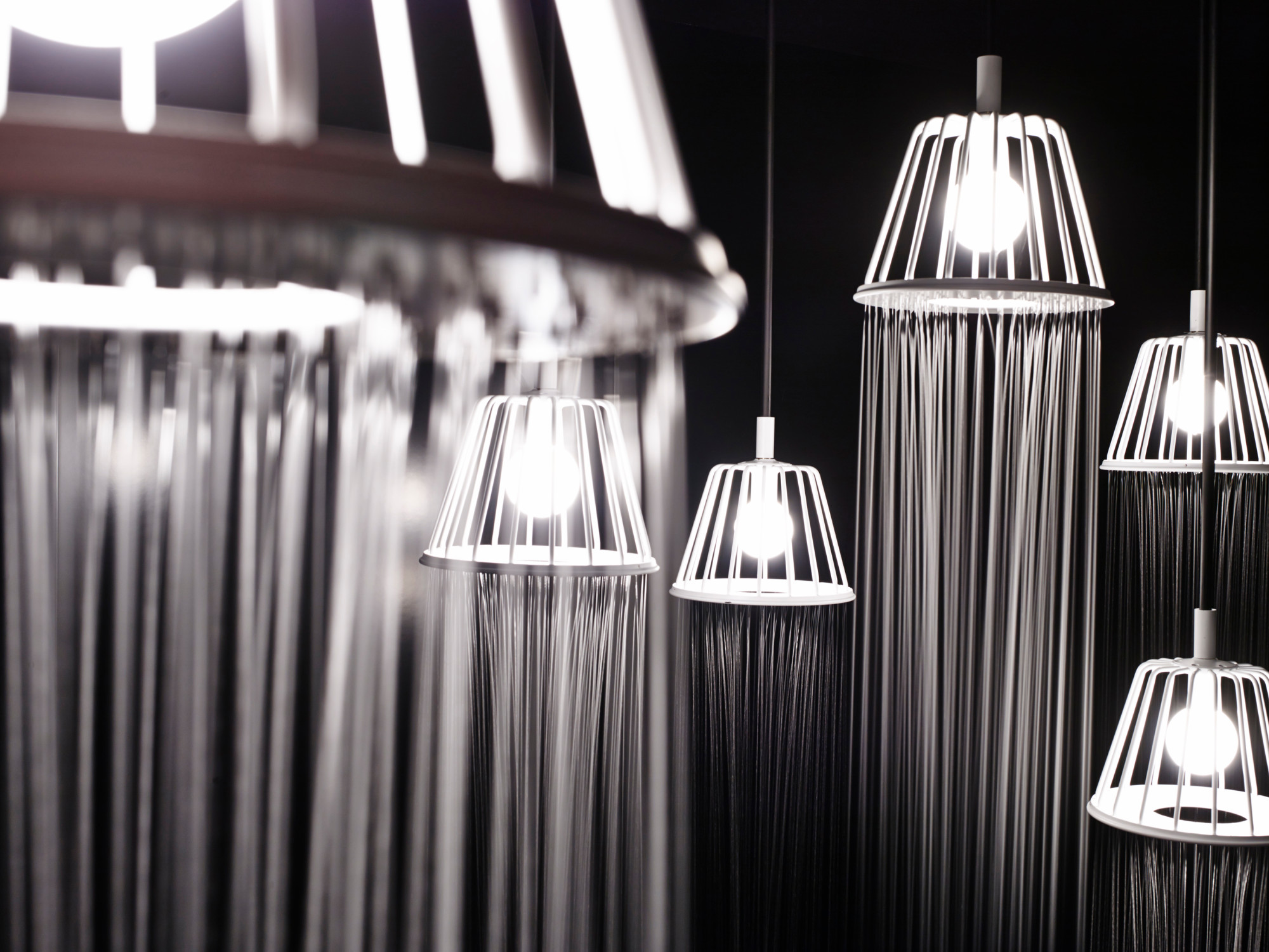 Hybrid aus Dusche und Wohnzimmerlampe: beleuchtete Wasserstrahlen als filigrane Linien beim Objekt von Nendo 