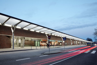 Die hellen Vordächer kontrastieren mit der Bahnhofsmauer aus roten Ziegeln und geben dem Bahnhof ein völlig neues Gesicht (Nordseite mit durchlaufender Überdachung)