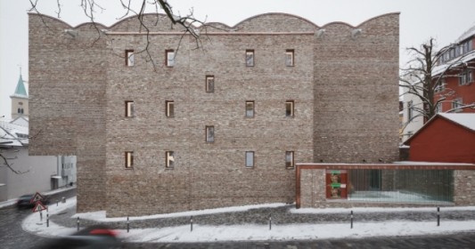 Ein schmaler Attikaabschluss aus Kupferblech betont die Dachkonturen und stellt eine optische Verbindung zu den Blechverkleidungen im Eingangsbereich her