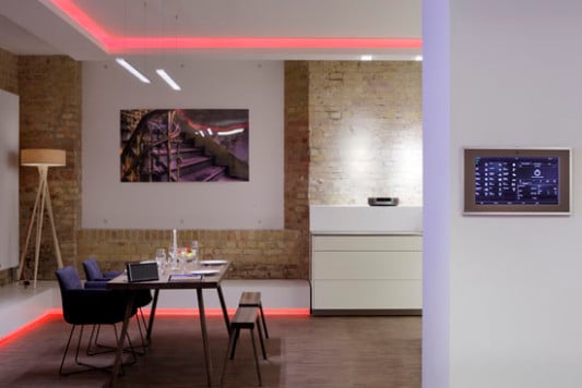 Im Showroom ist ein zentrales Bedienelement in die Wand eingelassen und ermöglicht per Touchscreen die Steuerung sämtlicher haustechnischer Geräte sowie Multimedia, Energie und Licht, Türkommunikation, Präsenz- und Rauchmelder