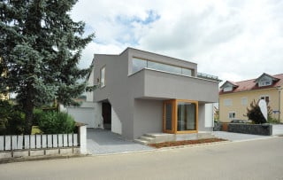 Das Wohnhaus aus den 1980er Jahren erhielt einen neuen Anbau mit dunkelgrauem Anstrich und Windfang aus Glas und Eiche