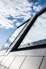 Das Dachflächenfenster ohne Sonnenschutz (Abb. li.) schließt flächenbündig mit der Dachhaut ab; das Fenster mit Sonnenschutz ist zurückversetzt, sodass der Screen in der Dachebene liegt (Abb. li.)