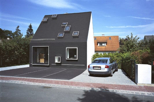 Der Bodenbelag des Vorplatzes scheint sich über das Haus zu legen