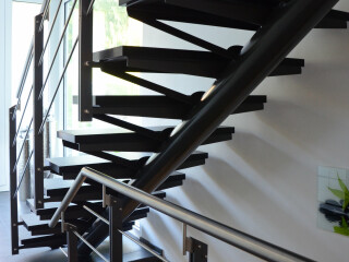 Geradläufige Treppe mit einem Mittelholm aus Stahlrohr.