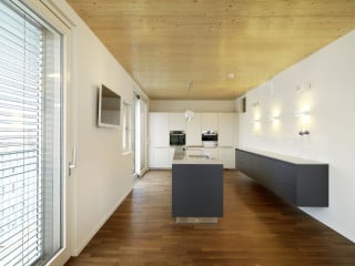 Mit seiner Fassade aus dunkelgrauen Faserzementtafeln bildet das Wohnhaus B26 einen starken Kontrast zu seinem weiß verputzten Nachbarn (Südostansicht)