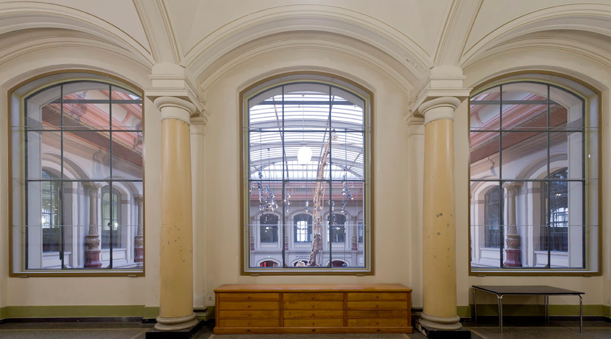 Hinter den Fenstern zum Sauriersaal kommen T30-Verglasungen in verdeckten, schmalen Stahlrahmen mit horizontalen Silikonfugen auf Höhe der Sprossen zum Einsatz