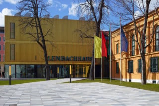 Der dreigeschossige Erweiterungsbau passt sich mit seiner profilierten, goldenen Fassade der Farbigkeit des Altbaus an