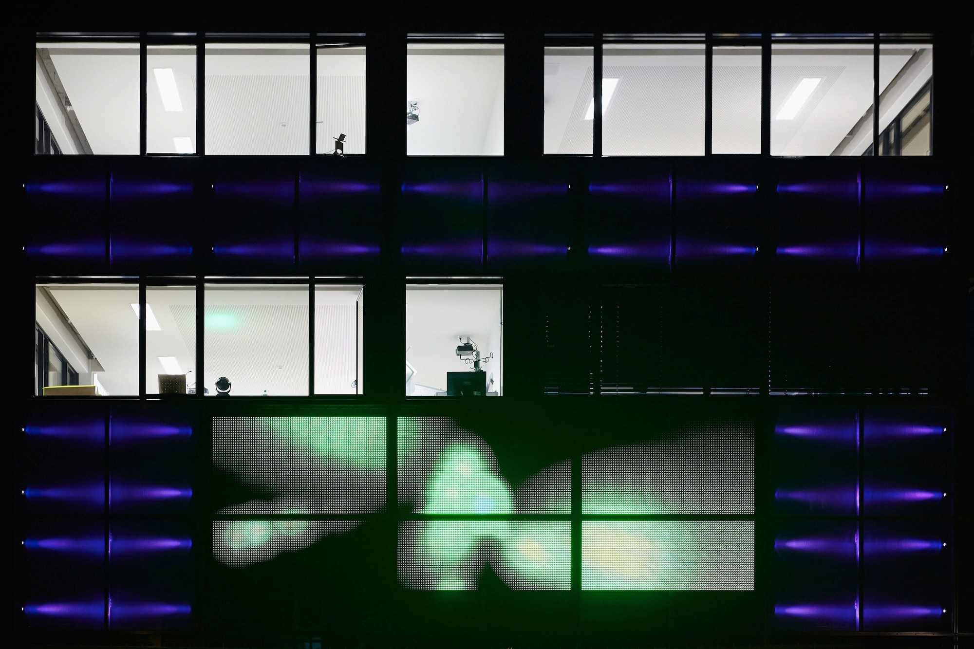 Das Forschungszentrum ist von einer glatten, anthrazitfarbenen Fassade mit liegenden Fensterformaten umhüllt