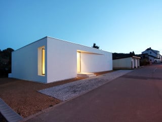 Zur Straße im Norden sowie zur angrenzenden Bebauung im Osten und Westen präsentiert sich der Bungalow weitgehend geschlossen