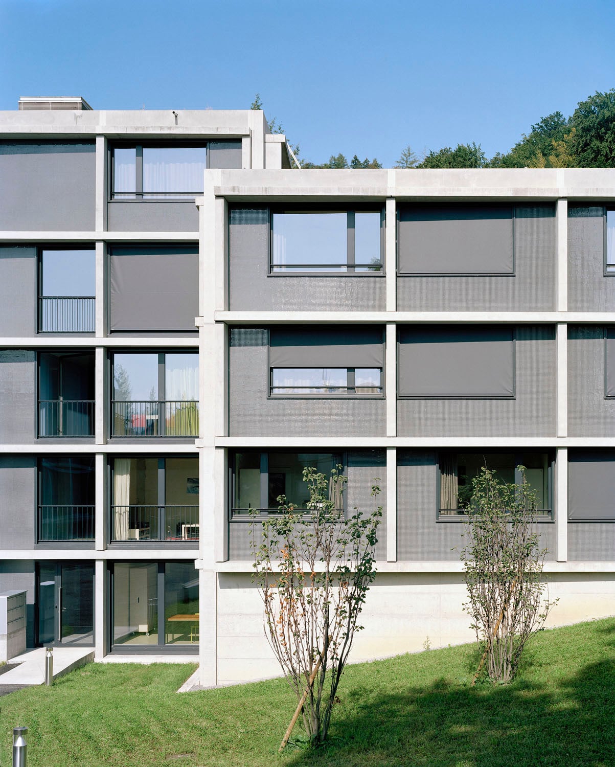 Beton-Fertigteilraster mit einzelnen Fassadenmodulen: Die Wohnraum-Module sind raumhoch verglast, die Brüstungen vor den Individualräumen geschlossen