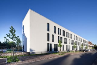 Der Multimedia- und Bühnenkomplex besteht aus zwei Baukörpern: Im Norden erstreckt sich der schmale Riegel mit weiß verputzter Rasterfassade