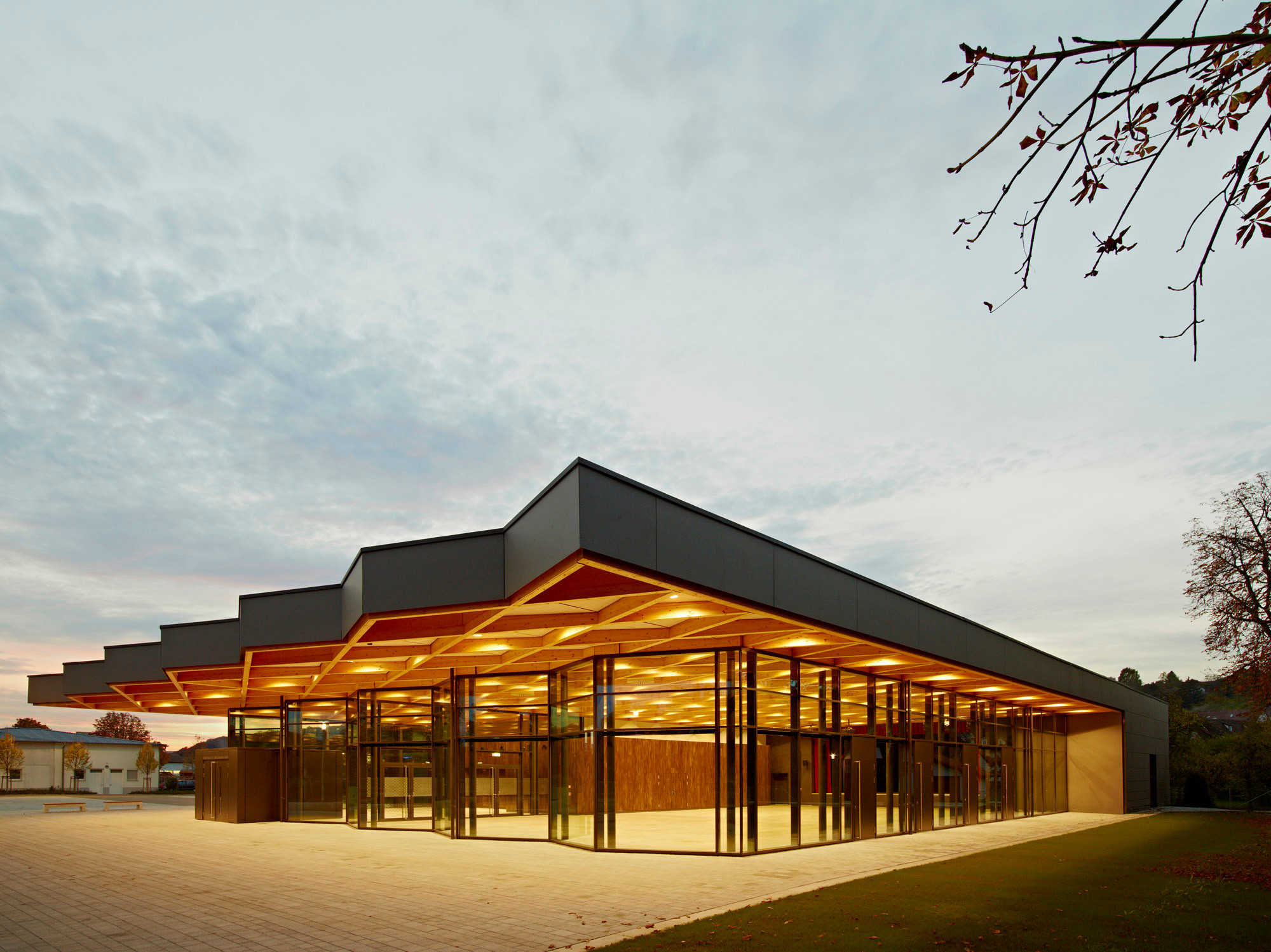 Das Dach überragt die gläserne Fassade der Festhalle nach Norden, Osten und Süden und bezieht den Außenraum mit ein