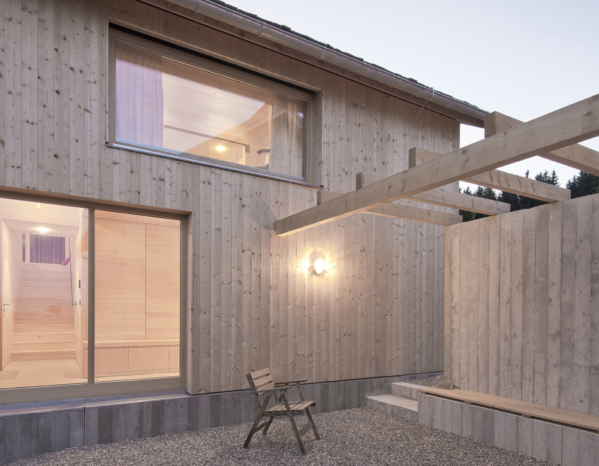 Zwischen Haupt- und Gästehaus ist eine Pergola mit Sitzplatz angeordnet
