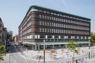 An der Munke-/Ecke Ebertstraße zeigt sich die Klinkerfassade mit horizontalen Gesimsbändern und schmalen, stehenden Fensterformaten (Ostansicht)