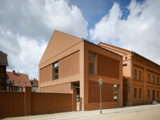 Mit seiner Fassade aus Backstein fügt sich das neue Haus gut in die traditionellen Mauerwerksbauten vor Ort; die Varianten des Mauerwerksverbands verleihen ihm zugleich ein modernes Erscheinungsbild