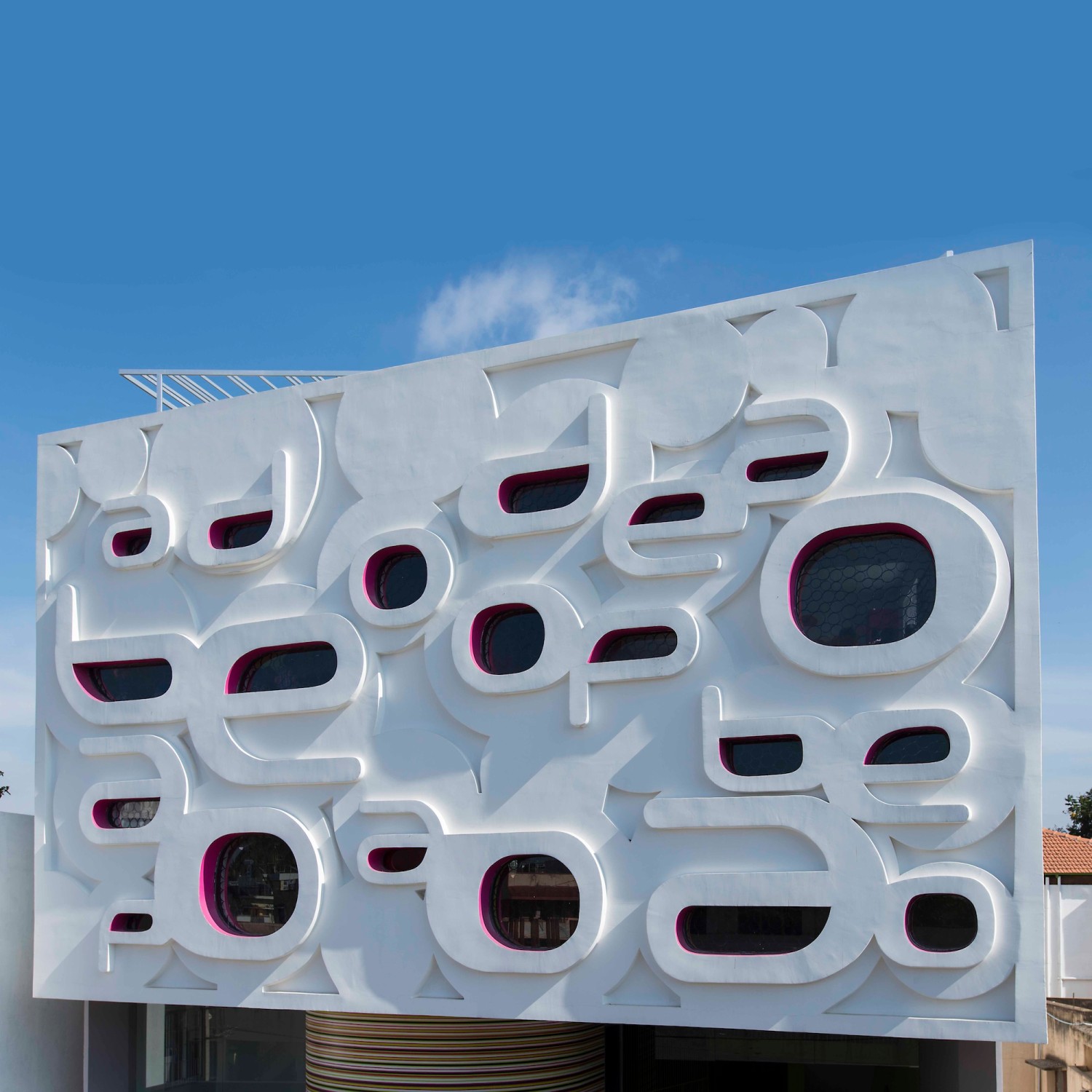 Die Buchstaben auf der Sichtbetonfassade gehen fließend ineinander über