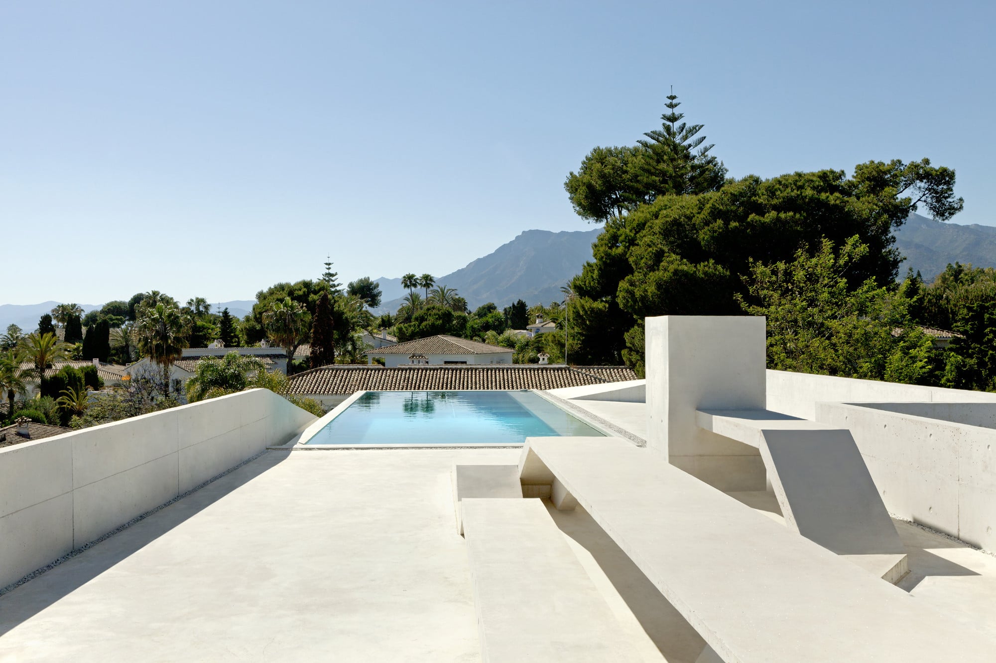 Der Pool auf dem Dach ist in eine Terrassenlandschaft aus Beton eingebettet
