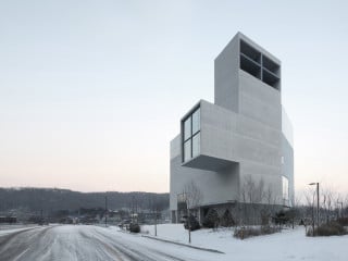 In der Gesamtansicht von Nordwesten erscheint das Gebäude wie ein stilisiertes Kreuz