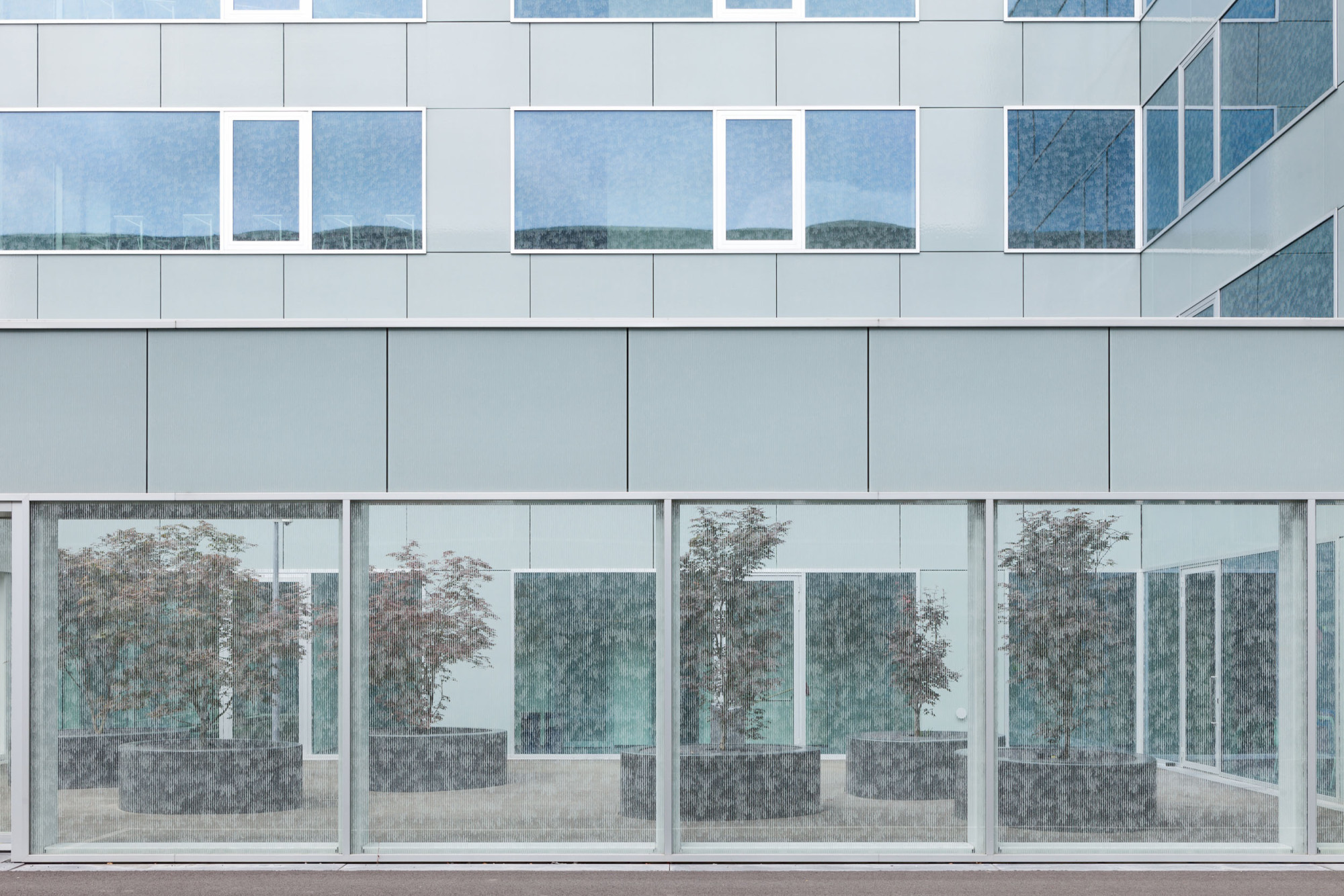 Blick in einen von der Glashülle umschlossenen, halböffentlichen Freibereich
